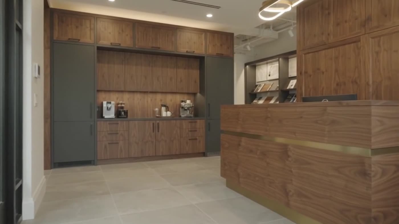 Commercial reception desk and cabinetry in walnut with brass detail